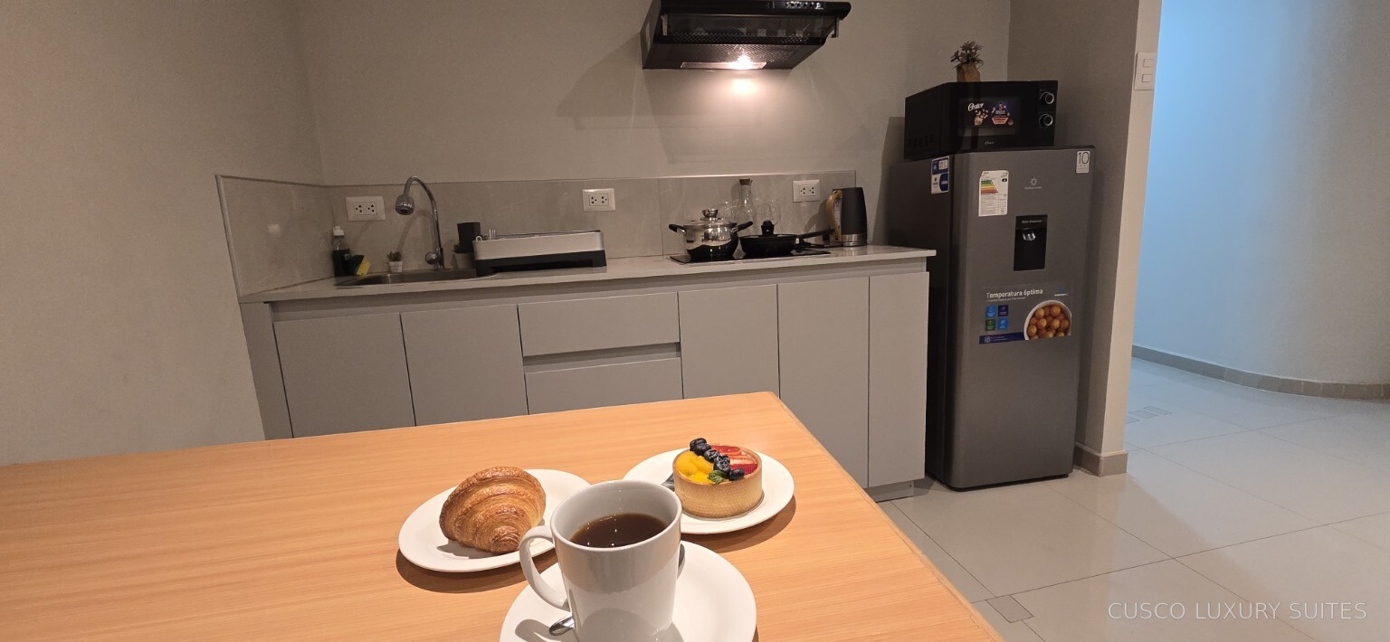 Fully equipped kitchen and dining table prepared for breakfast in SUMAQ SUITE